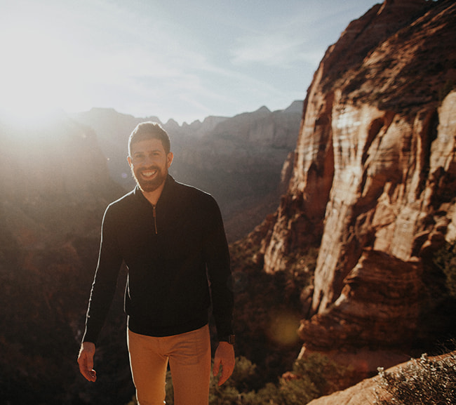 Man smiling with an amazing canyon view in the background