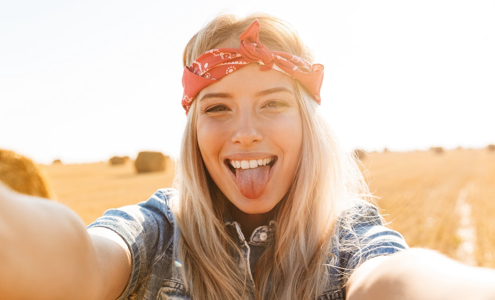 playful woman taking a selfie sticking her tongue out