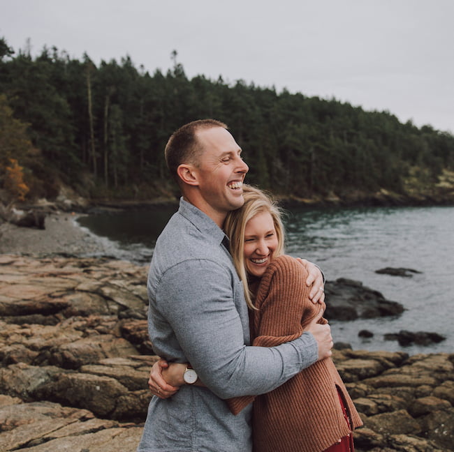 happy couple hugging on a rocky beach